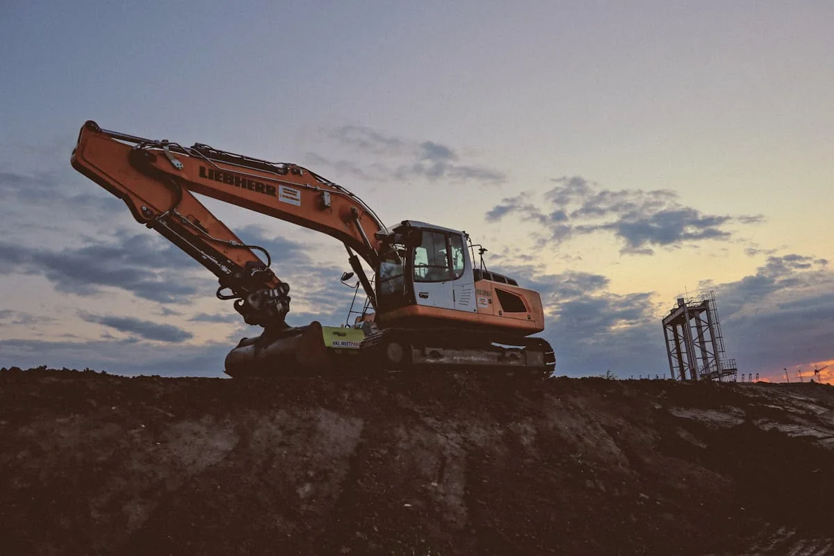 Construction equipment working at sunset